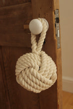 Load image into Gallery viewer, Country cottage inspired natural rope door stop, hand laid natural fibre cotton rope made in the UK crafted into a monkey fist knot doorstop
